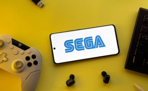 Dhaka, Bangladesh- 13 Sep 2025: Smartphone with Sega logo, game controller, and earbuds on a yellow