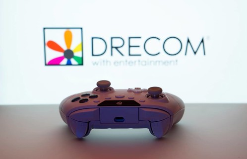 Dhaka, Bangladesh- 13 Sep 2025: A close-up of a white gamepad with the Drecom seen on screen in the