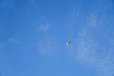 Paragliding on a sunny day with cirrus clouds, enjoying freedom and adventure in ronda, malaga,