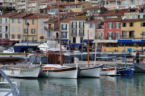 Cassis, the port, Boats docked in a harbor with colorful buildings lining the waterfront on an