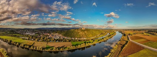 A picturesque landscape shows the Danube meandering through the green surroundings. Hills and