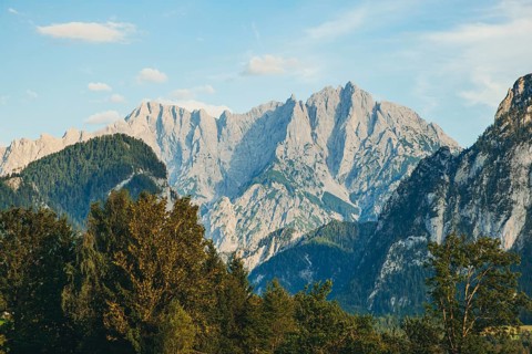 Imposing mountain peaks, Hochtor and Großer Ödstein, rise above wooded hills, Weng im Gesäuse,