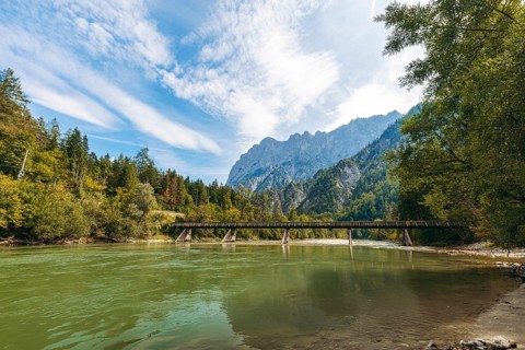 Wooden bridge over the Enns with stony bank and Reichenstein group in the background, Gesäuse,