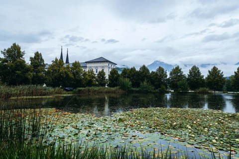 Admont Abbey behind a pond surrounded by trees, Admont, Styria, Austria