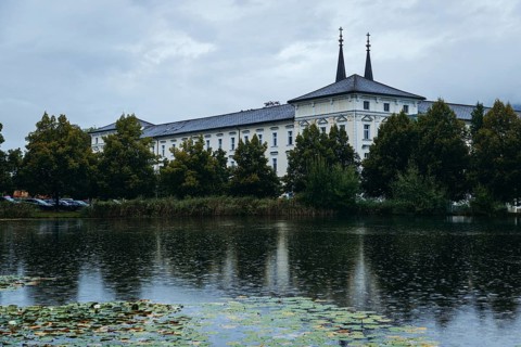 Admont Abbey is reflected in a pond surrounded by trees, Admont, Styria, Austria