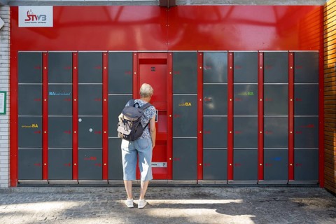 Woman standing in front of locker system, lockers, railway station, Bamberg, Upper Franconia,