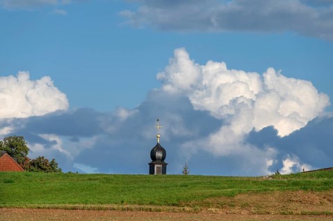 Tower of a chapel behind a meadow hill, cloudy sky, Köttweinsdorf, Upper Franconia, Bavaria,