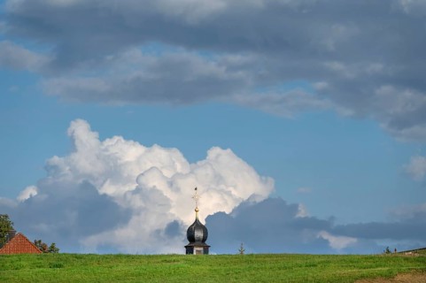 Tower of a chapel behind a meadow hill, cloudy sky, Köttweinsdorf, Upper Franconia, Bavaria,