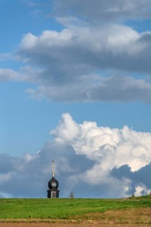 Tower of a chapel behind a meadow hill, cloudy sky, Köttweinsdorf, Upper Franconia, Bavaria,