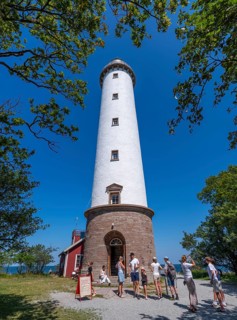Tourists stand in front of the Lange Erik lighthouse, Langer Erik, on the northern tip of the