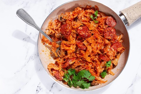 Bigos, Polish dish bigos, on a marble table, stewed meat with cabbage, chorizo sausages, mushrooms,
