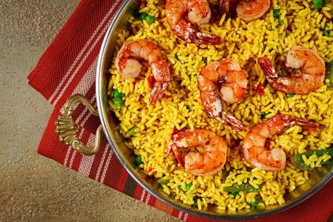 Rice with saffron and shrimp, in a frying pan, paella with shrimp, top view, homemade, no people