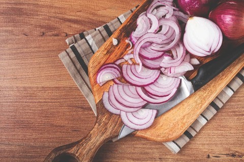 Sliced red onion, on a chopping board, with a knife, Spanish onion, raw onion, close-up, top view