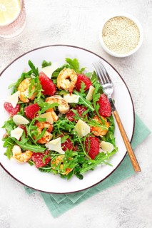 Fresh shrimp salad with arugula, grapefruit, and parmesan served in a bowl