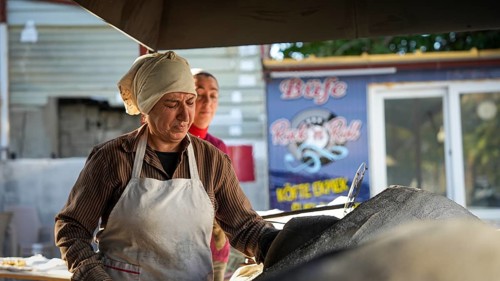 A Turkish woman bakes traditional bread on a clay tandoor oven in a rural village, Hatay, Hatay,