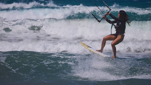 Woman kitesurfing sportily over the waves under a clear sky, Prasonisi, beach, surf, windsurfer,