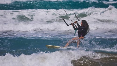 Woman kitesurfing energetically over waves in sunny sea environment, Prasonisi, beach, surf,