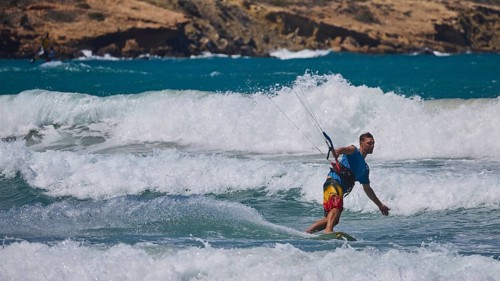 Kitesurfer riding elegant waves in sunny weather and blue sea, Prasonisi, beach, surf, windsurfer,