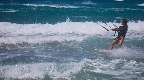 Kitesurfer gliding through moving waves in the ocean under blue sky, Prasonisi, beach, surf,
