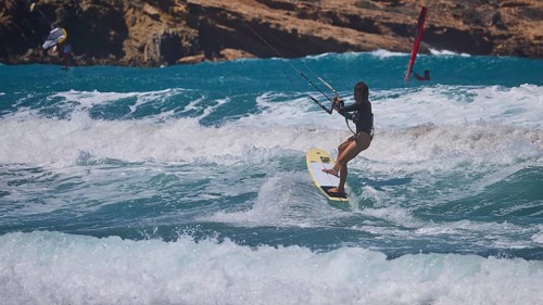 Kitesurfer skilfully navigates the waves off the rocky coast, Prasonisi, beach, surf, windsurfer,