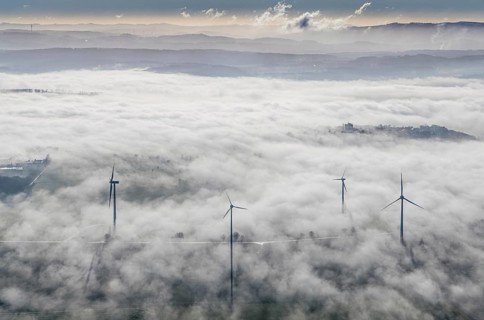 Aerial view, wind turbines in the fog and mountains of the Sauerland in the backlight in the