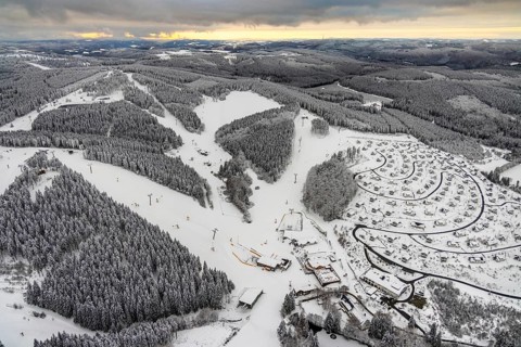 Aerial view of the snowy winter landscape of Winterberg with deserted ski lifts and slopes during