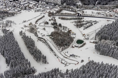 Aerial view of the snowy winter landscape of Winterberg with the St. Georg ski jump in the