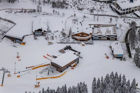 Aerial view of the snowy winter landscape of Winterberg with deserted ski lifts and slopes during