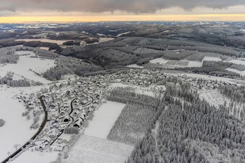 Aerial view of the snowy winter landscape of Winterberg with Altastenberg district in Sauerland in