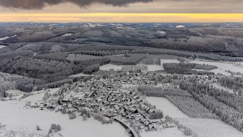 Aerial view of the snowy winter landscape of Winterberg with Altastenberg district in Sauerland in