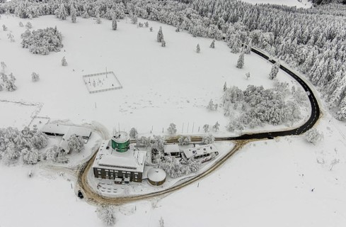 Aerial view of the snowy winter landscape of Winterberg am Kahlen Asten with Astenturm during