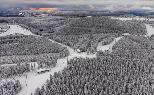 Aerial view of the snowy winter landscape of Winterberg with deserted ski lifts and slopes during