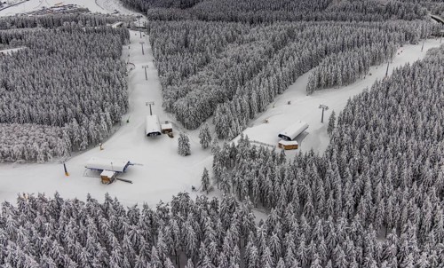 Aerial view of the snowy winter landscape of Winterberg with deserted ski lifts and slopes during