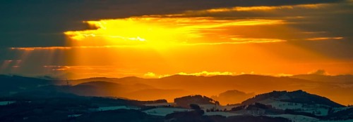 Aerial view of the sunset with a view over the snowy winter landscape from Winterberg to the