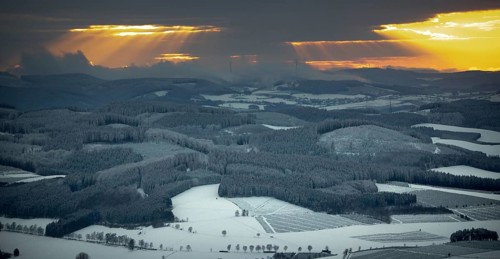 Aerial view of the sunset with a view over the snowy winter landscape from Winterberg to the