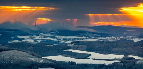 Aerial view of the sunset with a view over the snowy winter landscape from Winterberg to the