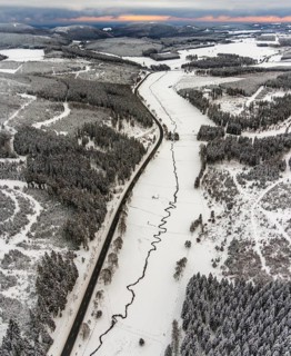 Aerial view of the Ruhr valley with the meandering Ruhr as a stream in the snowy winter landscape