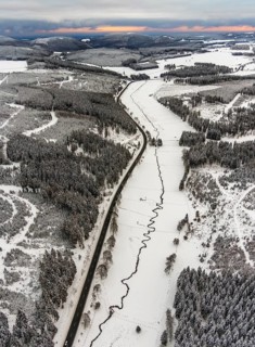 Aerial view of the Ruhr valley with the meandering Ruhr as a stream in the snowy winter landscape