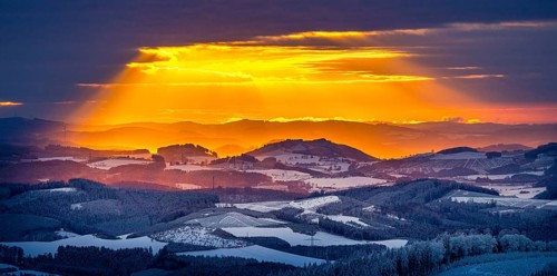Aerial view of the sunset with a view over the snowy winter landscape from Winterberg to the