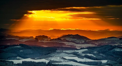 Aerial view of the sunset with a view over the snowy winter landscape from Winterberg to the
