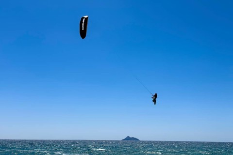 Kitesurfer kite surfer makes big high giant jump with kite kite sail over sea surface,