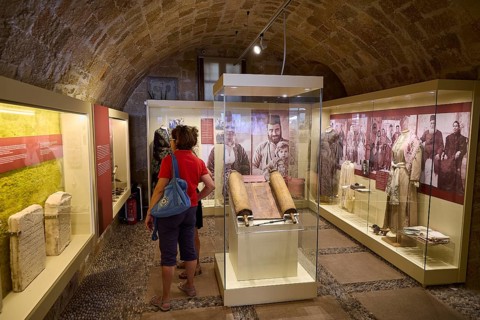 Museum exhibition with manuscripts and visitors in historic vaults, Kahal Shalom Synagogue,