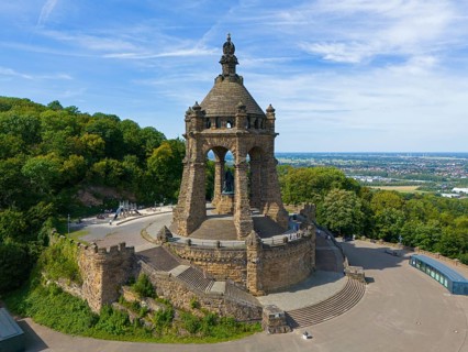 A monumental building on a hill, surrounded by trees and a sweeping view, aerial view, Kaiser