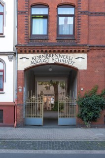 Photograph of the entrance to an old grain distillery with a wrought-iron golden Tor tor, Hainholz,