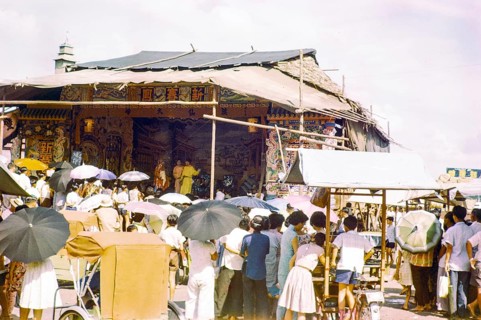 Audience watching Chinese theatre performance at the old market, Johor Bahru, Johor, Malaya,