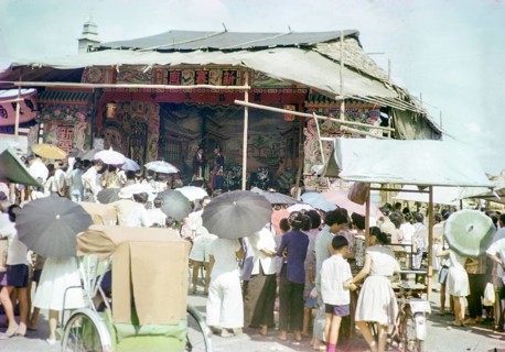 Audience watching Chinese theatre performance at the old market, Johor Bahru, Johor, Malaya,