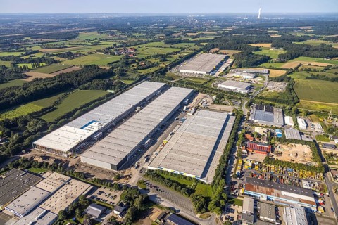 Aerial view of an extensive industrial area with many warehouses and surrounding fields, aerial