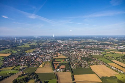 Aerial view of a town with surrounding fields and forest under a blue sky, aerial view Werl