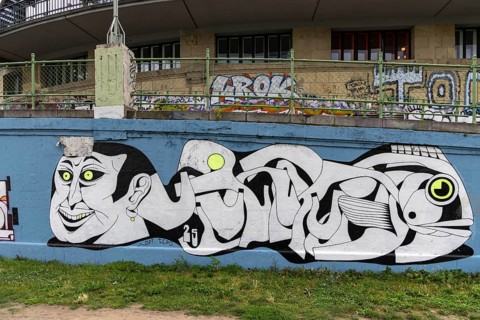 Stylised graffiti artwork on a wall with abstract shapes and faces Urania Ringstraße Vienna Austria