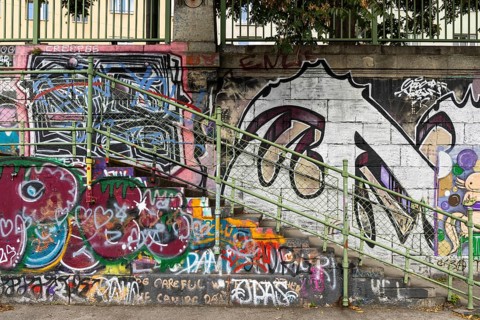 Diverse graffiti with lettering on a concrete wall next to a staircase, Am Donaukanal Innere Stadt